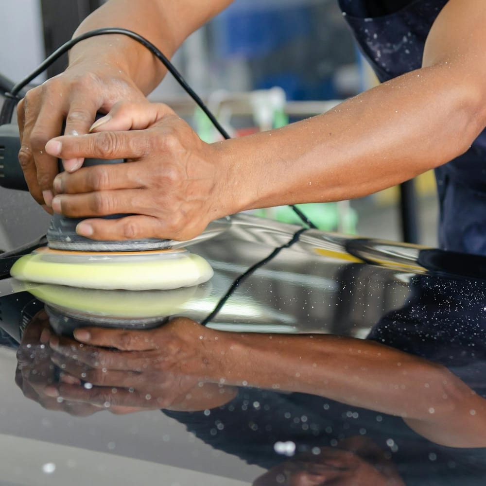 Detailer hand-polishing a freshly corrected hood
