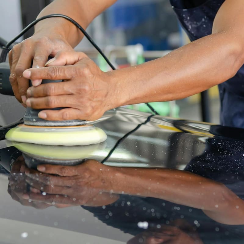 Polish pad gliding across a freshly corrected hood