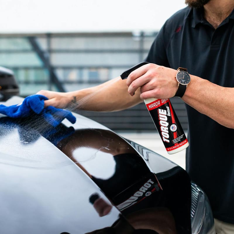 Spray detailer and microfiber on deep black paint